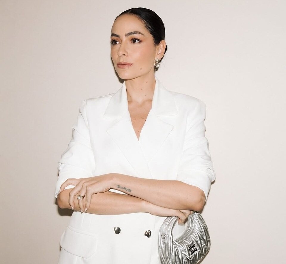 Alfaiataria branca moderna com blazer e bolsa Miu Miu, seguindo tend&ecirc;ncias em alfaiataria sofisticada, acess&oacute;rios met&aacute;licos e estilo elegante para oc